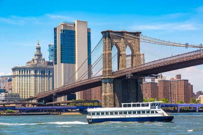 2260438893 featured image Boat passing under Brooklyn Bridge in New York