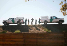 Border Patrol vehicles and agents on a ridge
