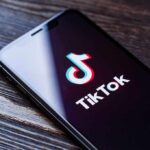 Phone screen showing TikTok logo and app