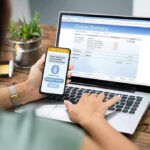 Person using online banking on laptop and smartphone