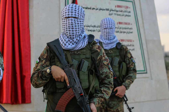 Masked soldiers holding rifles in front of a monument
