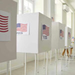 Voting booths with American flag and VOTE signs