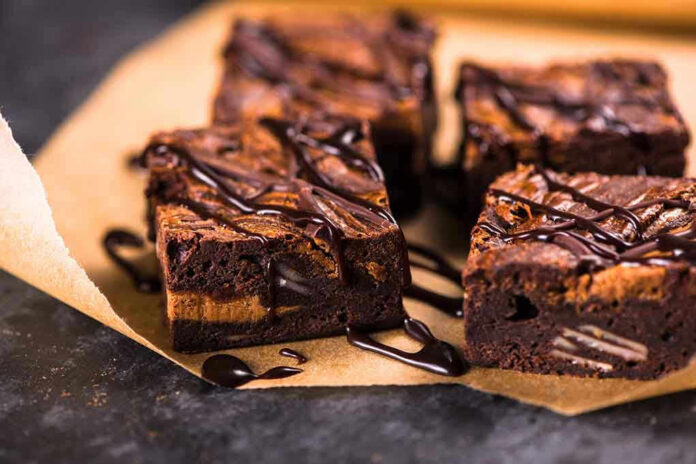 Chocolate brownies with drizzled chocolate on parchment paper