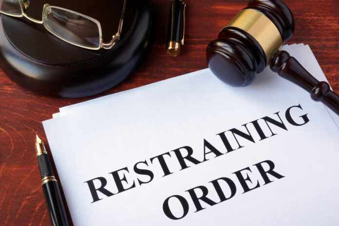 shutterstock_548148202.jpg featured image Gavel glasses pen restraining order document on table