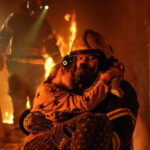 Firefighter rescues child from burning building.