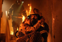Firefighter rescues child from burning building.