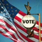 A vintage 'Vote' sign in front of an American flag