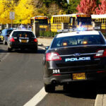 Police cars and school buses on a road