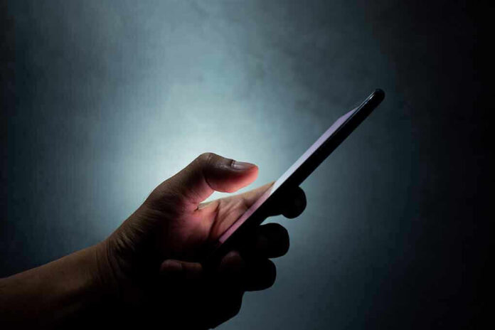 Hand holding a smartphone in dim light