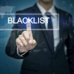 Wikipedia BLACKLIST Exposed—Top Voices Erased Man pressing virtual blacklist button