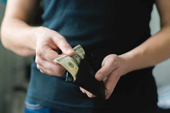 Person holding a wallet with cash inside