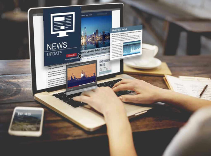 Person reading news websites on a laptop.