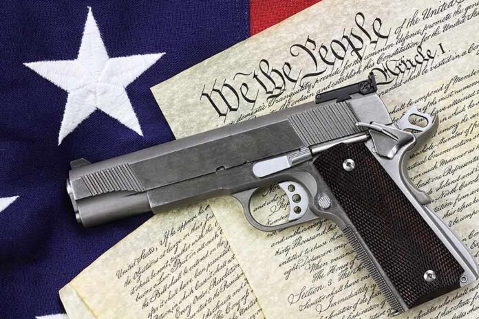 A handgun placed on top of the US Constitution and an American flag