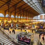 Visa Crackdown STUNS Foreign Activists Interior view of a busy train station with large windows and a staircase