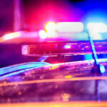 Close-up of police car lights flashing at night.