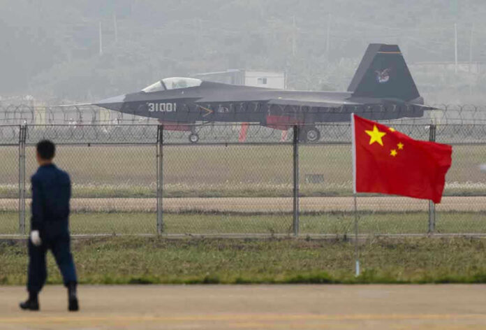 Jet with 31001 marking behind barbed wire fence.