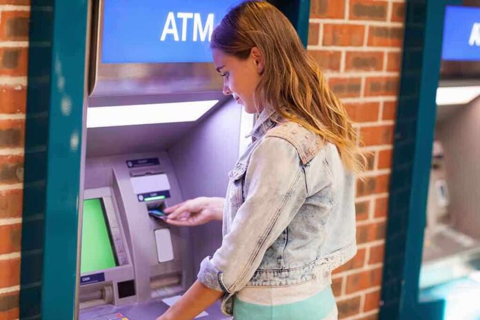 Young woman using an ATM in an urban environment