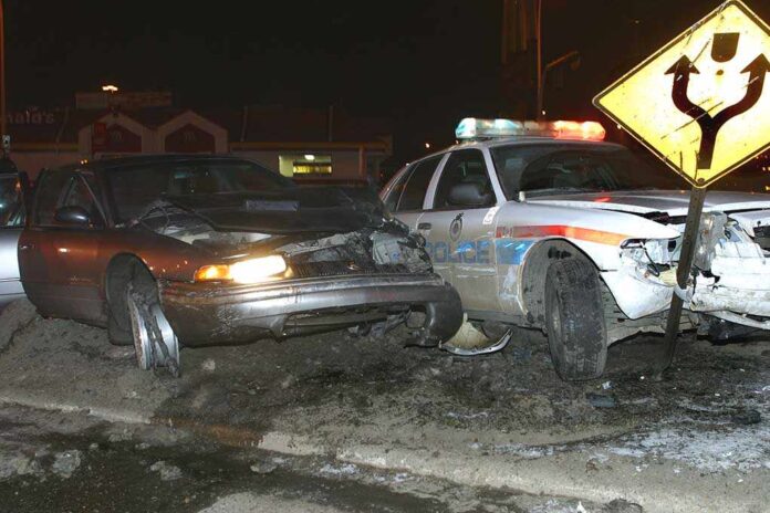 A damaged car and a police vehicle involved in a nighttime accident