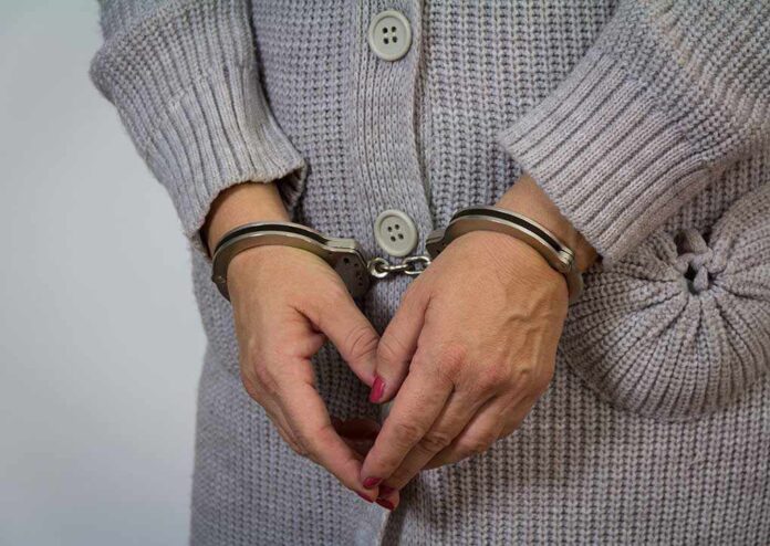 A person wearing handcuffs with their hands clasped together