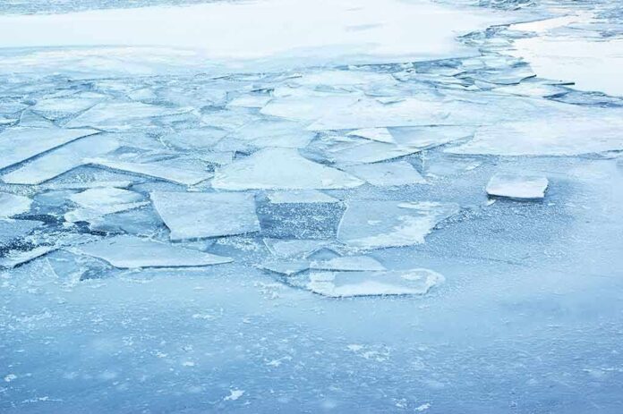 A frozen lake with cracked ice and blue hues