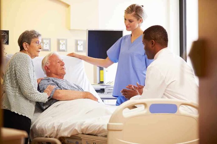 A nurse and a doctor discussing with a patient and his family in a hospital room