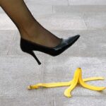 Banana Cargo Disaster — Toxic Fruits Wash Ashore A high heel shoe poised above a banana peel on a tiled floor