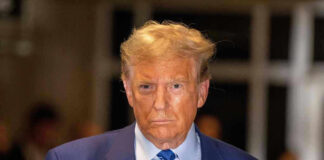 Man in blue suit and striped tie, serious expression.