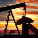 Massive Oil Reserves NOW Under U.S. Control – What We Get Silhouette of an oil pump jack against a sunset background with an American flag overlay