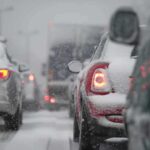 Icy Mayhem: 100+ Vehicles Trapped! Cars stuck in traffic during a snowstorm with snow covering the vehicles