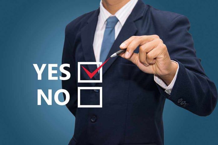 Business professional indicating a yes choice with a pen