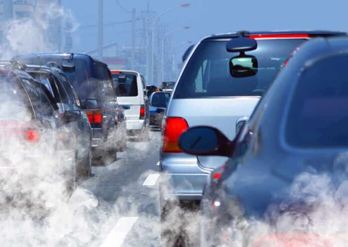 Traffic jam with cars emitting exhaust fumes on a city road