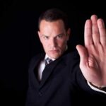 Businessman in a suit making a stop gesture with his hand
