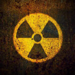 Hidden Nuclear Threat Rivals Taiwan Crisis — Nobody Noticed Yellow radiation warning symbol on rusty metal surface.