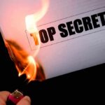Benghazi Arrest: Justice Department’s Secret Move A hand holding a lighter igniting a paper labeled TOP SECRET as it catches fire