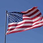 Waving American flag against a clear blue sky