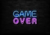 Game Over neon sign on brick wall.