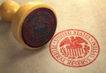 Fed’s Rate Pause: What’s the REAL Story? Federal Reserve stamp and wooden stamp on paper