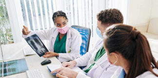 Doctors discussing chest X-ray results at a workstation.