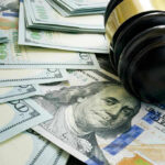NYC Fines STORES for Theft—Not Thieves Gavel and hundred dollar bills on table.