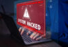Warning sign System Hacked on laptop screen.