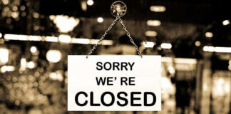 Closed sign hanging in a shop window.