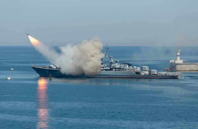 Warship firing missile in the sea.