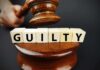 Dem Rep FOUND GUILTY: FACING Years in PRISON A gavel striking down next to wooden blocks spelling 'GUILTY'