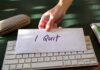 A hand placing an envelope labeled 'I Quit' on a keyboard