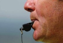 Close-up of a sports coach blowing a whistle