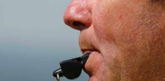 Close-up of a sports coach blowing a whistle