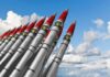 New War Front Shocks Washington A row of military missiles with red tips and nuclear symbols against a blue sky