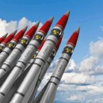 New War Front Shocks Washington A row of military missiles with red tips and nuclear symbols against a blue sky