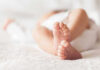 Close-up of baby feet lying on blanket.