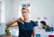 Woman with thumbs down in voting location.